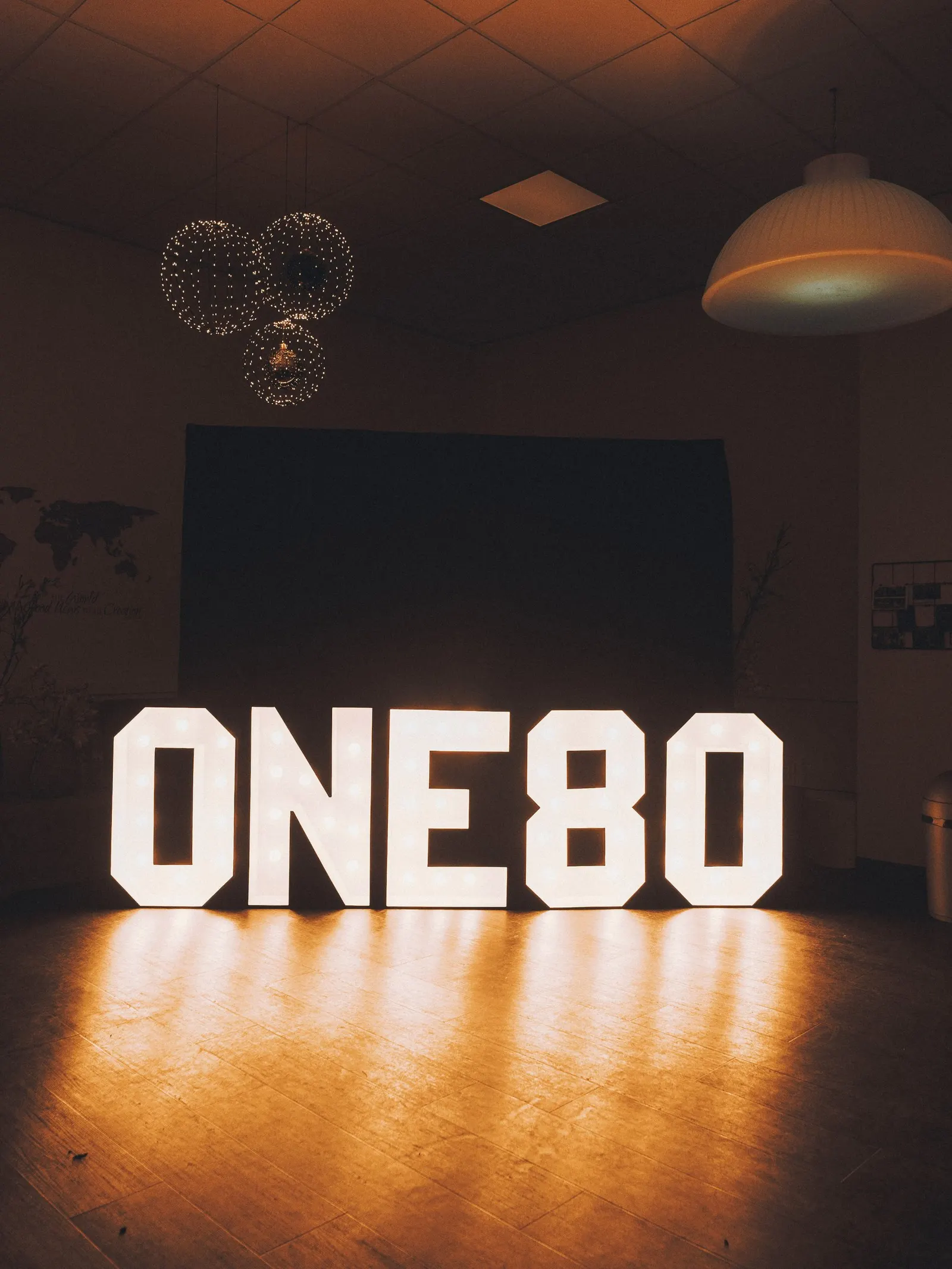 Lichtgevende letters ONE80 op de vloer van de zaal