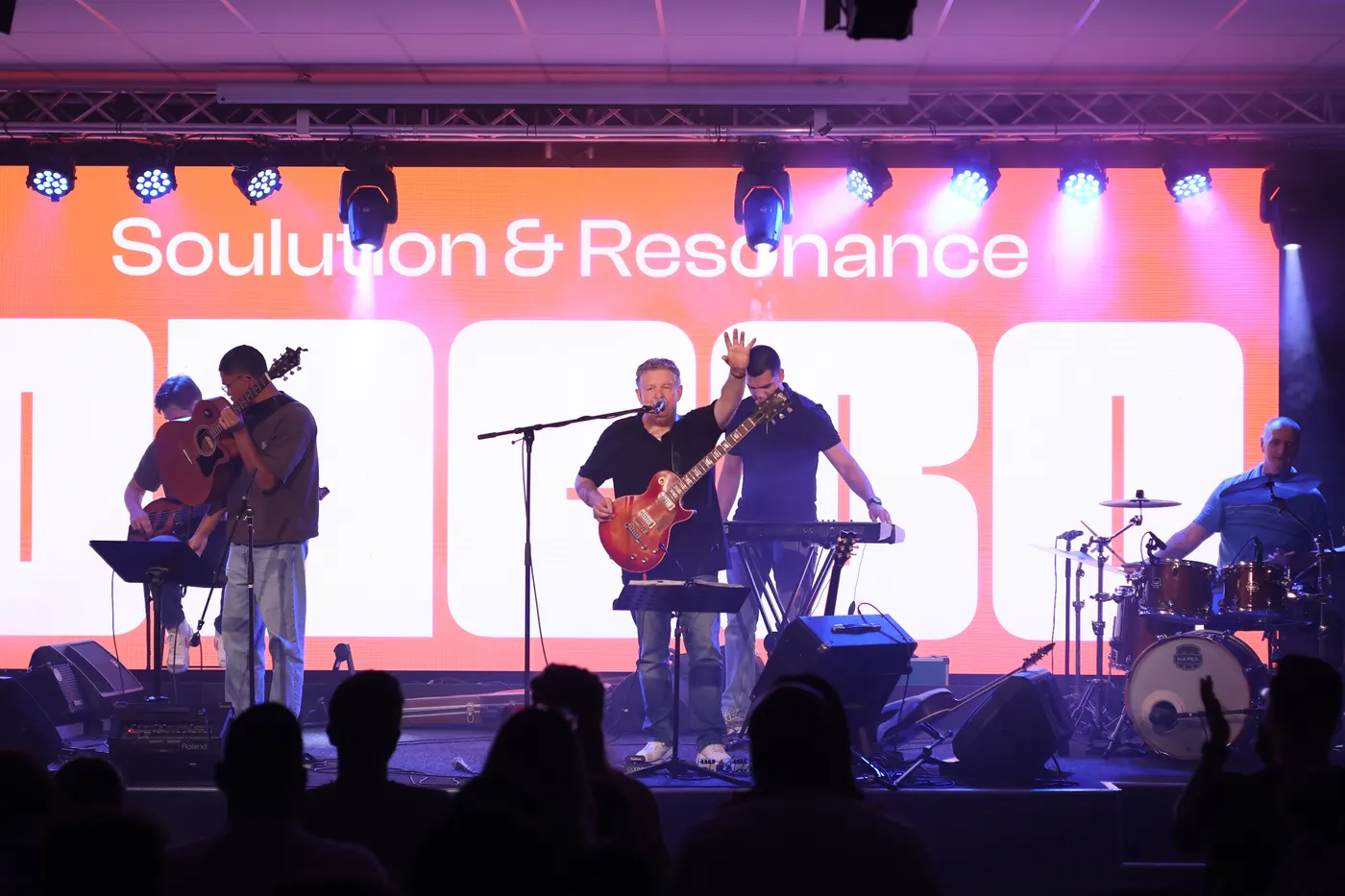 Een band speelt op een podium voor een vol publiek